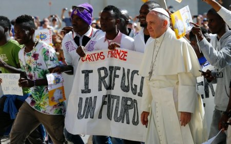 Pope Francis waves as he arrives, flanked by a group of refugees, to lead his Wednesday general audience in Saint Peter's square at the Vatican June 22, 2016.