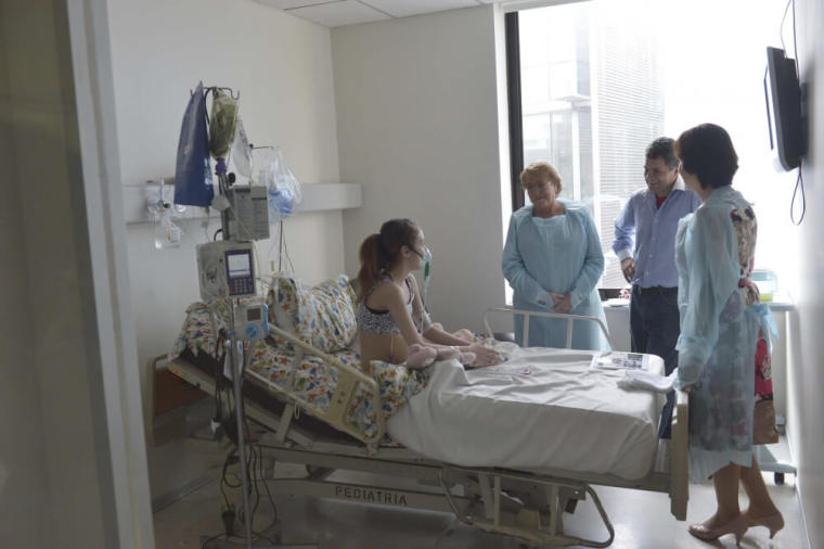 Valentina Maureira (L-R), a 14-year old girl who suffers from cystic fibrosis, Chile's President Michelle Bachelet, Valentina's father Freddy Maureira and Health Minister Carmen Castillo meet at a hospital room in Santiago, Chile, February 28, 2015.