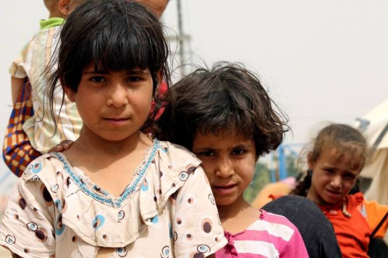 Displaced children, who fled from the Islamic State violence, pose for photographer at a refugee camp in the Makhmour area near Mosul, Iraq, June 17, 2016.