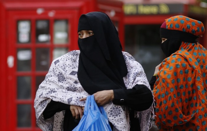 Women wears a full-face veil as they shop in London September 16, 2013. As the British government considers how to better integrate Britain's 2.7 million Muslims without restricting the right to freedom of religious expression, it has steered clear of following the examples of France and Belgium, where it is illegal for women to wear full-face veils in public.