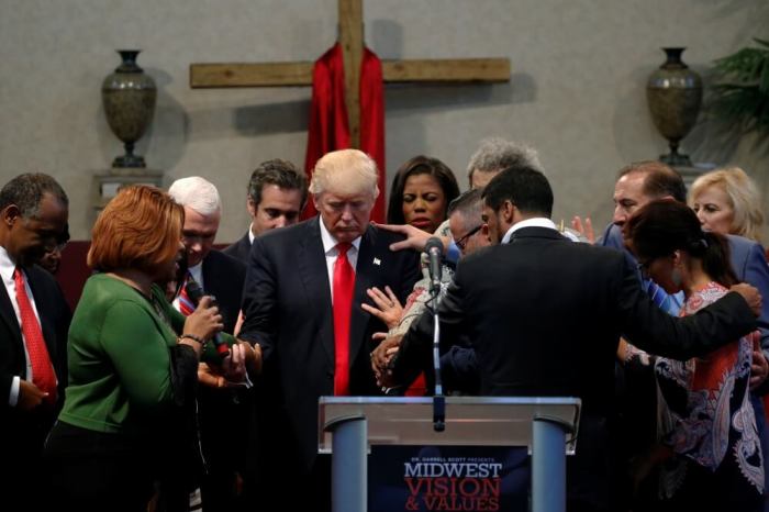 Members of the clergy lay hands and pray over Republican presidential nominee Donald Trump at the New Spirit Revival Center in Cleveland Heights, Ohio, U.S. September 21, 2016.