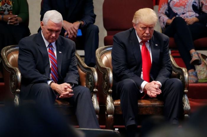 Then Republican presidential nominee Donald Trump (right) and vice presidential nominee Governor Mike Pence bow their heads in prayer before addressing pastors at the New Spirit Revival Center in Cleveland Heights, Ohio, U.S. on Sept. 21, 2016.