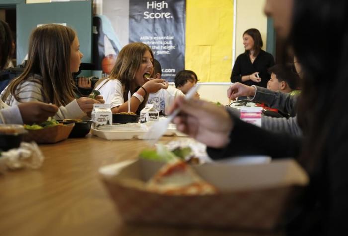 Students eat lunch in the cafeteria at a middle school in San Diego, California March 7, 2011.