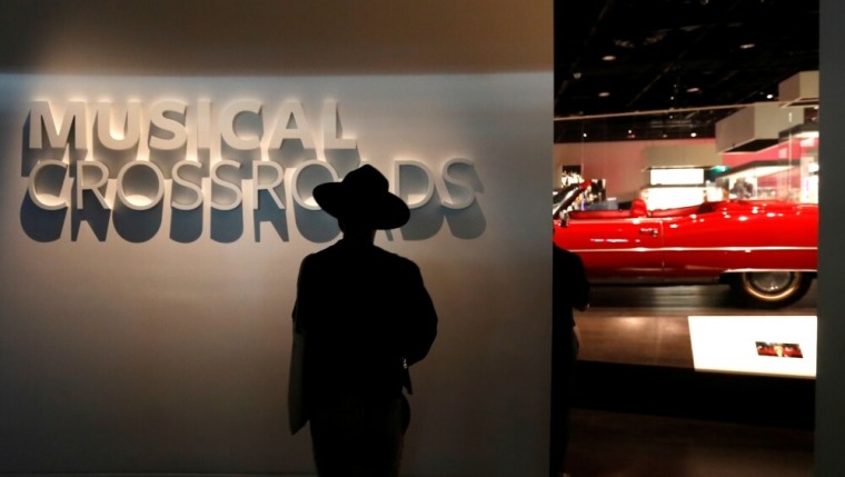 A man walks from a music exhibit, featuring Chuck Berry's Cadillac Eldorado (behind), during a media preview at the National Museum of African American History and Culture on the National Mall in Washington, U.S., September 14, 2016. The museum will open to the public on September 24.