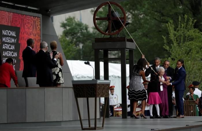U.S. President Barack Obama with First Lady Michelle Obama and the Bonner family ring the onstage bell during dedication and grand opening of the Smithsonian Institution's National Museum of African American History and Culture in Washington, U.S., September 24, 2016.