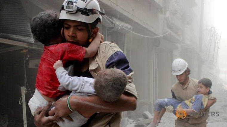 Members of the civil defence rescue children after what activists said was an air strike on September 25, 2016 by forces loyal to Syria's President Bashar al-Assad in al-Shaar neighborhood of Aleppo.