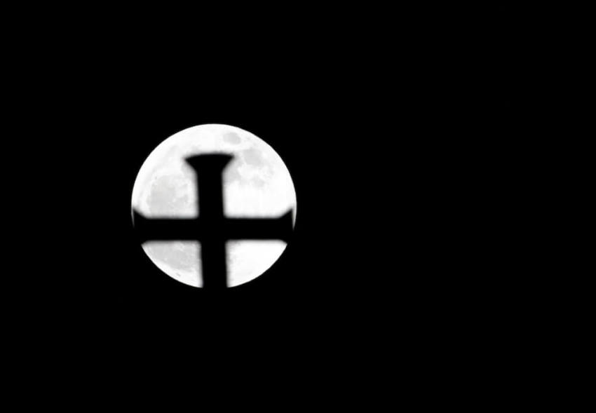 The cross of the Holy Trinity Cathedral is silhouetted against the moon at the start of a total "supermoon" lunar eclipse in Port-of-Spain, September 27, 2015. Sky-watchers around the world were treated when the shadow of Earth cast a reddish glow on the moon, the result of rare combination of an eclipse with the closest full moon of the year. The total "supermoon" lunar eclipse, also known as a "blood moon" is one that appears bigger and brighter than usual as it reaches the point in its orbit that is closest to Earth.