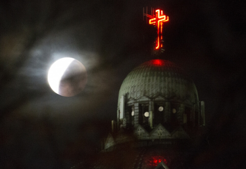 The dome of the Koekelberg Basilica is seen during a total "supermoon" lunar eclipse in Brussels, Belgium, September 28, 2015. Sky-watchers around the world are in for a treat Sunday night and Monday when the shadow of Earth casts a reddish glow on the moon, the result of rare combination of an eclipse with the closest full moon of the year.