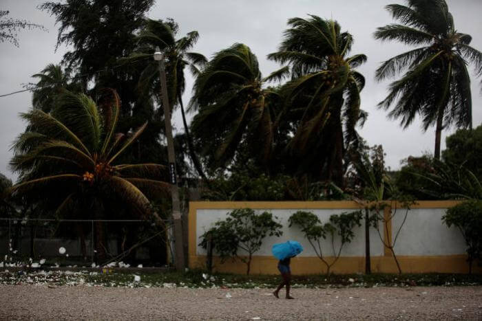 A woman protects herself from rain with an umbrella ahead of Hurricane Matthew in Les Cayes, Haiti, October 3, 2016.