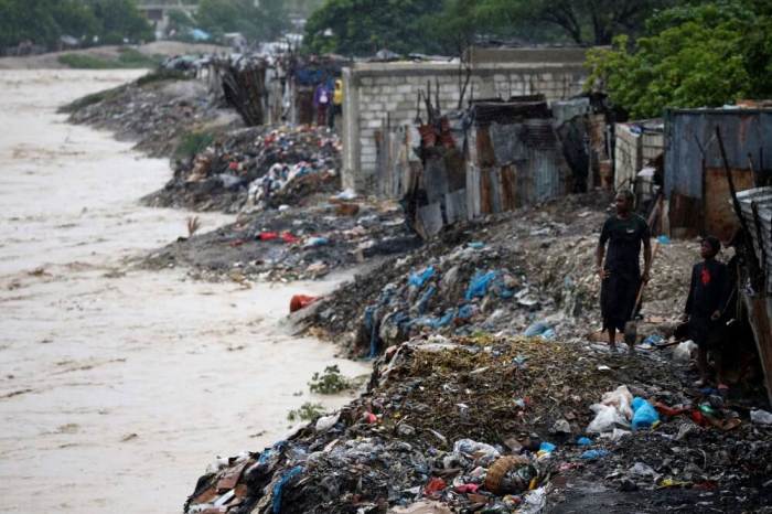 People inspect the rising water level of a river due to the rains caused by Hurricane Matthew passing through Port-au-Prince, Haiti, October 4, 2016.