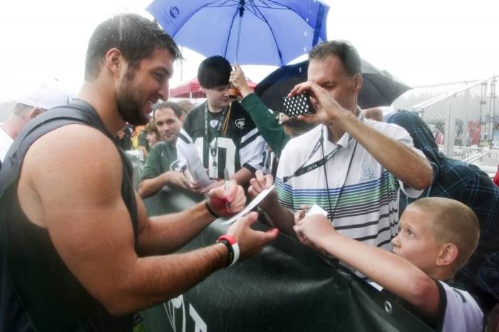 New York Jets quarterback Tim Tebow signs autographs after the Jets training camp practice in Cortland, New York, July 28, 2012.