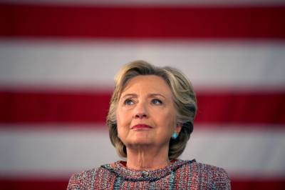 U.S. Democratic presidential nominee Hillary Clinton listens to Vice President Al Gore talk about climate change at a rally at Miami Dade College in Miami, Florida, October 11, 2016.