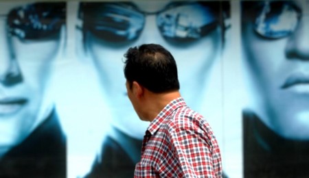 A man walks past posters promoting the U.S. movie "The Matrix Reloaded" in Beijing July 16, 2003. The film debuted in some theatres in Beijing on Wednesday but most theaters will begin screening it from July 18.