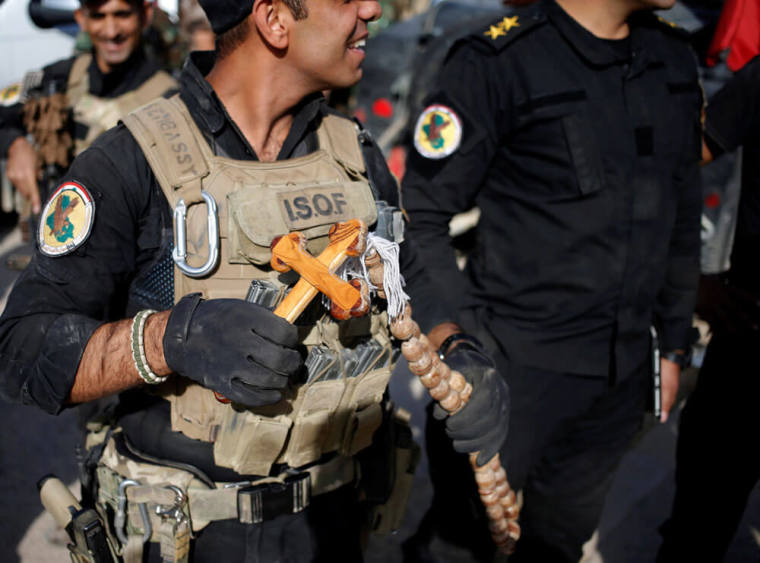 A Christian Iraqi special forces soldier holds a cross in Bartella, east of Mosul, Iraq October 22, 2016.