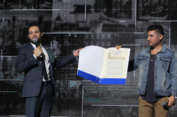 Jonathan Soto (L), senior community liaison in the Community Affairs Unit from the office of New York City Mayor Bill de Blasio holds up a proclamation from the mayor declaring October 27, 2016, 'Movement Day.' Assisting him with the proclamation is Grant Skeldon, founder of INITIATIVE, a missional millennial network that exists to change culture by making millennials Christ-loving, city-changing, church-investing local missionaries.