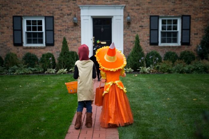 Kids dressed in costumes wait for candy while trick or treating during Halloween in Port Washington, New York, October 31, 2014.