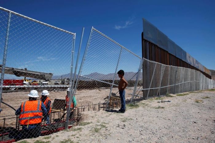 A boy looks at U.S. workers building a section of the U.S.-Mexico border wall at Sunland Park, U.S. opposite the Mexican border city of Ciudad Juarez, Mexico, September 9, 2016. Picture taken from the Mexico side of the U.S.-Mexico border.