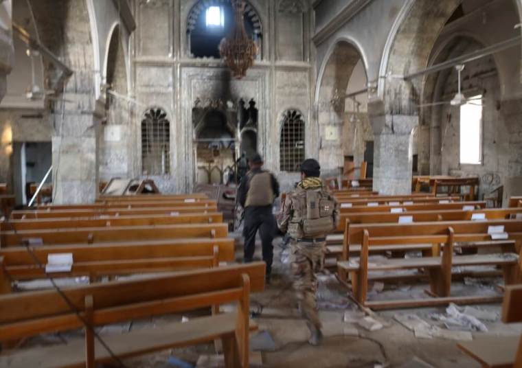 Iraqi special forces soldiers walk inside a church damaged by Islamic States fighters in Bartella, east of Mosul, Iraq, October 21, 2016.