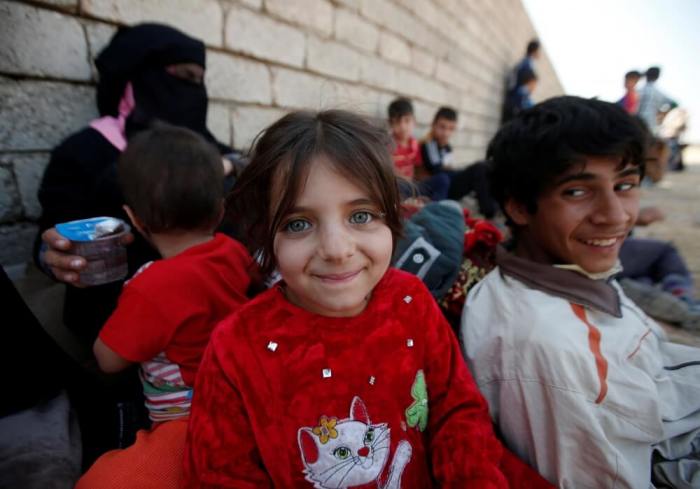 An Iraqi girl smiles after escaping from the Islamic State-controlled village of Abu Jarboa, Iraq, October 31, 2016.