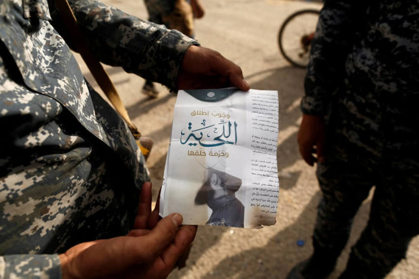 An Iraqi soldier shows a pamphlet which reads "Wearing beards is compulsory, shaving is prohibited" along a street of the town of al-Shura, which was recaptured from Islamic State (IS) on Saturday, south of Mosul, Iraq October 30, 2016.