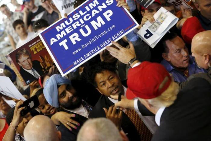 U.S. Republican presidential nominee Donald Trump signs autographs for supporters holding a Muslim Americans for Trump sign after a rally in Harrington, Delaware April 22, 2016.