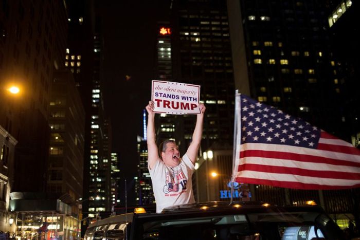 A supporter of U.S. Republican presidential candidate Donald Trump cheers near the intersection of West 54th Street and Fifth Avenue in New York, November 9, 2016.