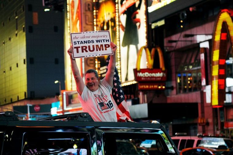 A man leans out of a Hummer shouting words in support of U.S. Republican presidential nominee Donald Trump while driving through Times Square in New York, November 9, 2016.