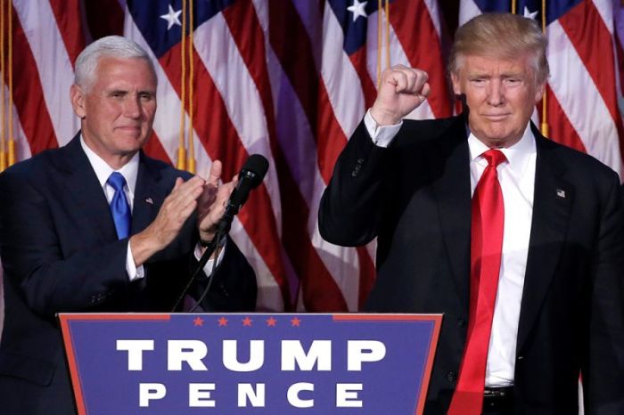 U.S. President-elect Donald Trump gestures as Vice President-elect Mike Pence applauds (L) at their election night rally in Manhattan, New York, November 9, 2016.