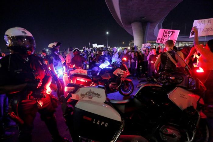 Police are surrounded by demonstrators who took over the Hollywood 101 Freeway just north of Los Angeles City Hall in protest to the election of Republican Donald Trump as President of the United States in Los Angeles, California, November 9, 2016