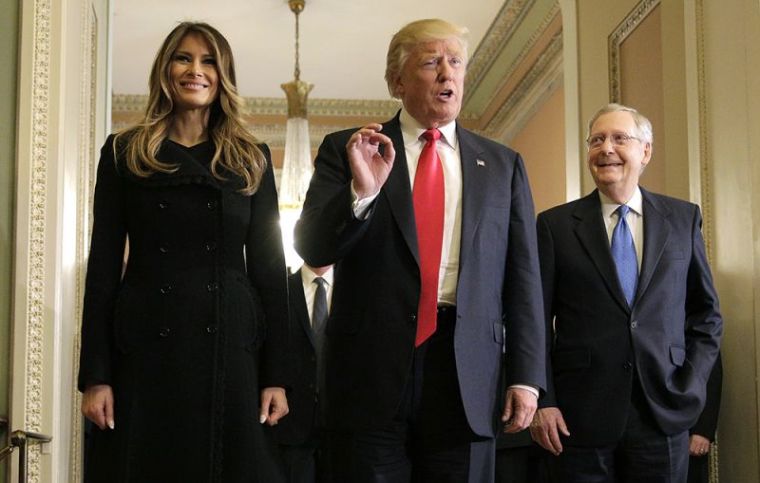 U.S. President-elect Donald Trump (C) answers questions as his wife Melania Trump and Senate Majority Leader Mitch McConnell, R-Ky., watch on Capitol Hill in Washington, November 10, 2016.