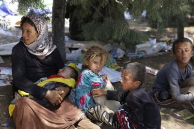 A displaced family from the minority Yazidi sect, fleeing the violence in the Iraqi town of Sinjar, waits for food while resting at the Iraqi-Syrian border crossing in Fishkhabour August 13, 2014.