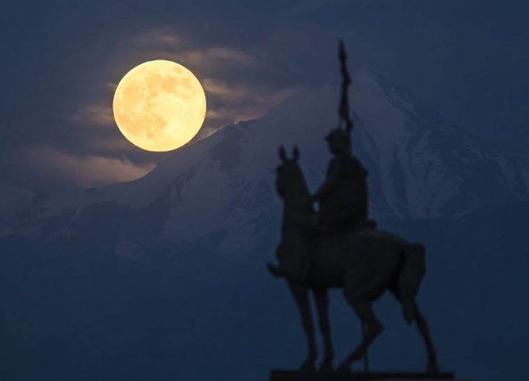 The largest full moon of 2013, a 'super moon' scientifically known as a 'perigee moon', rises over the Tien Shan mountains and the monument to 18th century military commander Nauryzbai Batyr near the town of Kaskelen, some 23 km (14 miles) west of Almaty, Kazakhstan, June 23, 2013.