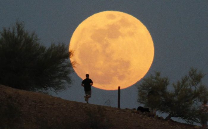 A runner makes his way along a trail on a butte in front of the 'super Moon' at Papago Park in Phoenix, Arizona, May 5, 2012. A 'super Moon' will light up Saturday's night sky in a once-a-year cosmic show, overshadowing a meteor shower from remnants of Halley's Comet, the U.S. space agency NASA said. The Moon will seem especially big and bright since it will reach its closest spot to Earth at the same time it is in its full phase, NASA said.