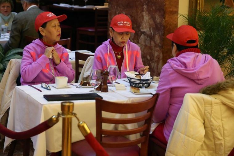 Women wearing Make America Great Again hats sit at a table at Trump Bar at the offices of Republican president-elect Donald Trump at Trump Tower in New York, New York, November 14, 2016.