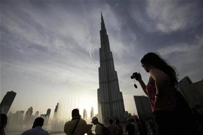 Tourists take photographs of Burj Khalifa, the world's tallest tower in Dubai which stands at 828 metres, May 3, 2010.
