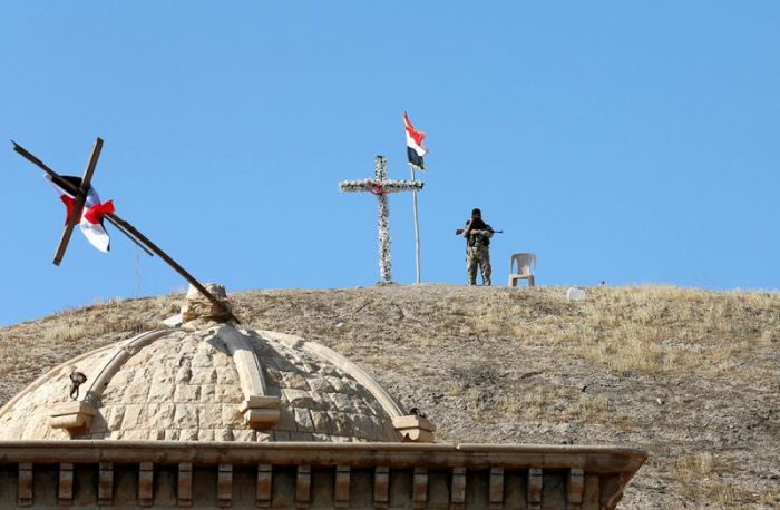 An Iraqi Christian soldier guards the church of Saint Barbara after it was recaptured from Islamic State in Qaraqosh, near Mosul in Iraq, October 30, 2016.