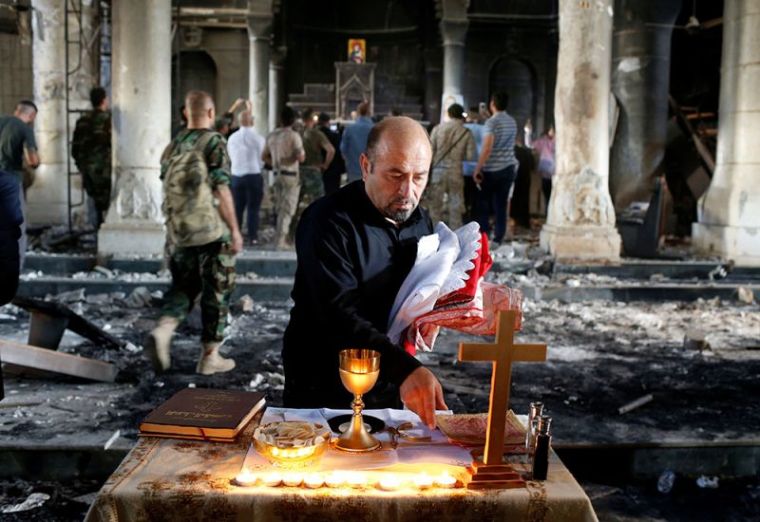 An Iraqi Christian prepares for the first Sunday mass at the Grand Immaculate Church since it was recaptured from Islamic State in Qaraqosh, near Mosul in Iraq, October 30, 2016.