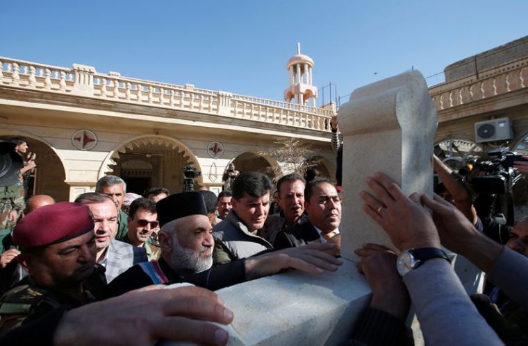 Iraqi Christians take part in a procession to erect a new cross over the Mar Korkeis church, after the original cross was destroyed by Islamic State militants, in the town of Bashiqa, Iraq, November 19, 2016.