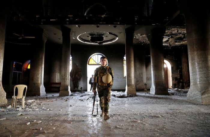 An Iraqi Christian soldier attends the first Sunday mass at the Grand Immaculate Church since it was recaptured from Islamic State in Qaraqosh, near Mosul in Iraq, October 30, 2016.