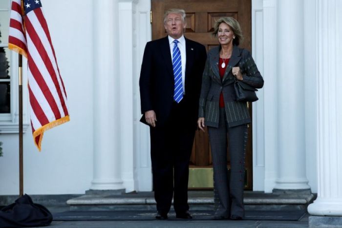 U.S. President-elect Donald Trump (L) stands with Betsy DeVos after their meeting at the main clubhouse at Trump National Golf Club in Bedminster, New Jersey, U.S., November 19, 2016.