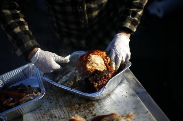 A volunteer carves a deep fried turkey at a Thanksgiving dinner cooked and served by volunteers in the Staten Island borough of New York November 22, 2012.