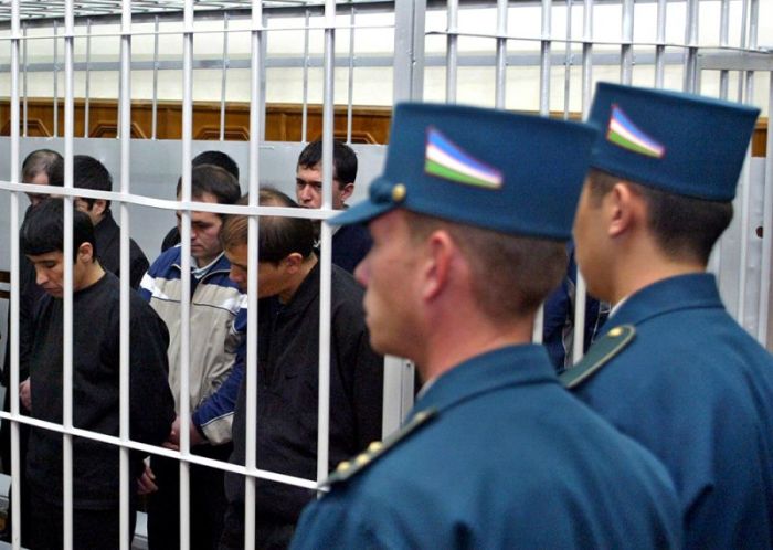Uzbek men who are accused of plotting a bloody rebellion in Andizhan in May wait in a metal defendants cage in a courtroom in Tashkent, Uzbekistan, November 14, 2005.