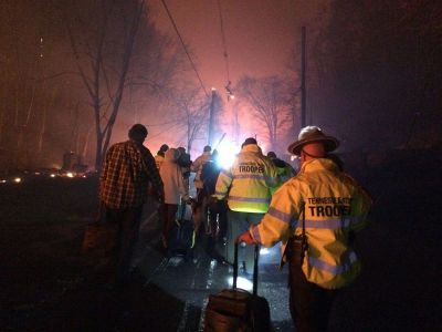 Troopers from the Tennessee Highway Patrol help residents leave an area under threat of wildfire after a mandatory evacuation was ordered in Gatlinburg, Tennessee, in a picture released November 30, 2016.