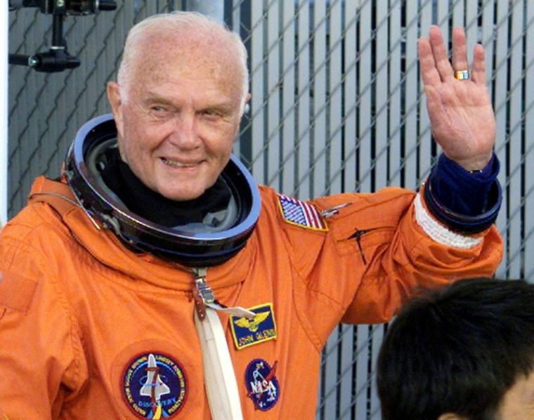 Astronaut John Glenn waves with crewmates as they depart crew quarters for the launching pad at the Kennedy Space Centre October 29, 1998.