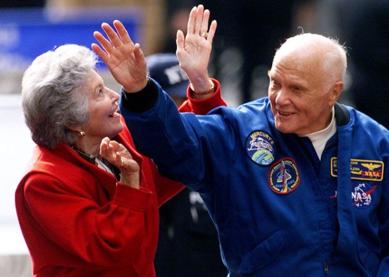 Astronaut John Glenn waves to the cheering crowd as he rides in an open car with his wife Annie during a ticker tape parade down New York's 'Canyon of Heroes' on lower Broadway, November 16, 1998.