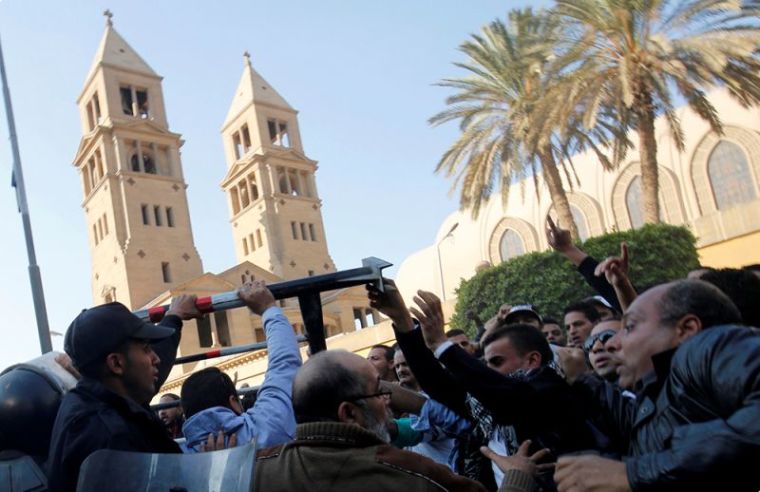 Christians shout slogans and clash with riot police in front of Cairo's Coptic Cathedral after an explosion inside the cathedral in Cairo, Egypt December 11, 2016.