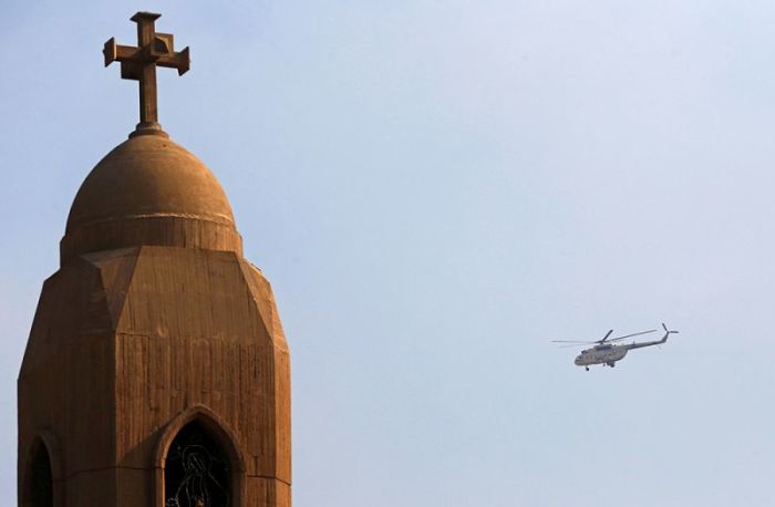 A military helicopter flies above the Virgin Mary church during the funeral for victims killed in the bombing of Cairo's main Coptic cathedral, in Cairo, Egypt December 12, 2016.