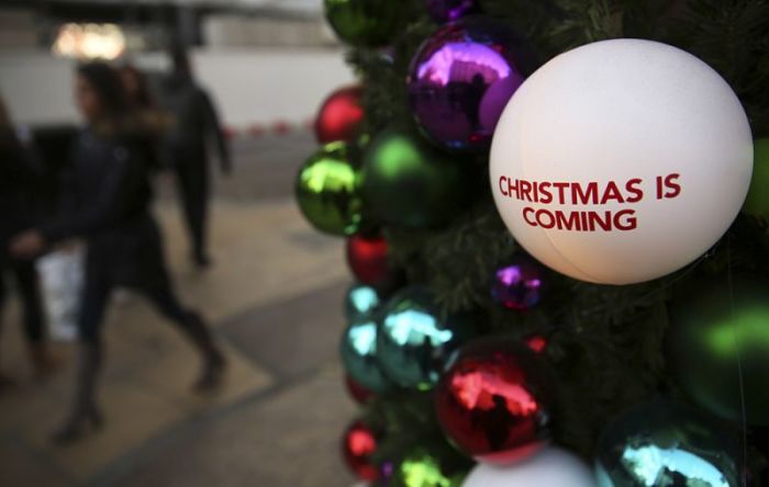Shoppers walk past Christmas decorations in London, Britain, December 3, 2016.