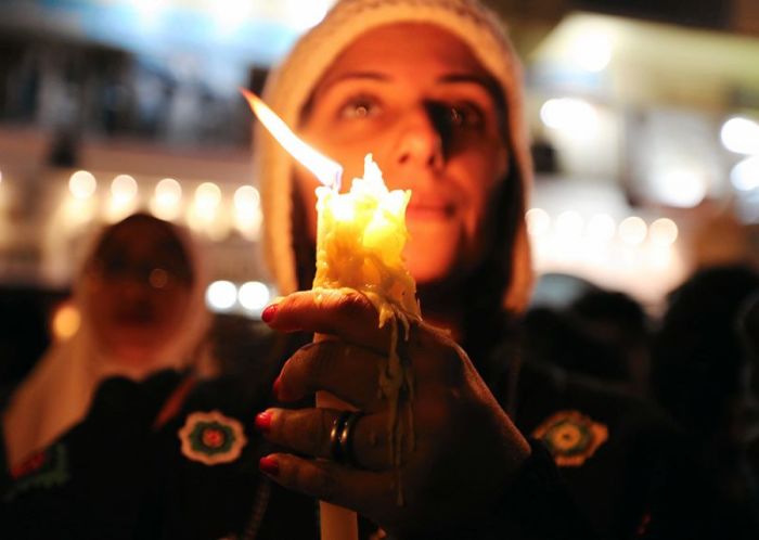 An Egyptian woman holds a melting candle at a vigil in downtown Cairo, following a deadly explosion inside a Coptic cathedral in Cairo, Egypt, December 14, 2016.