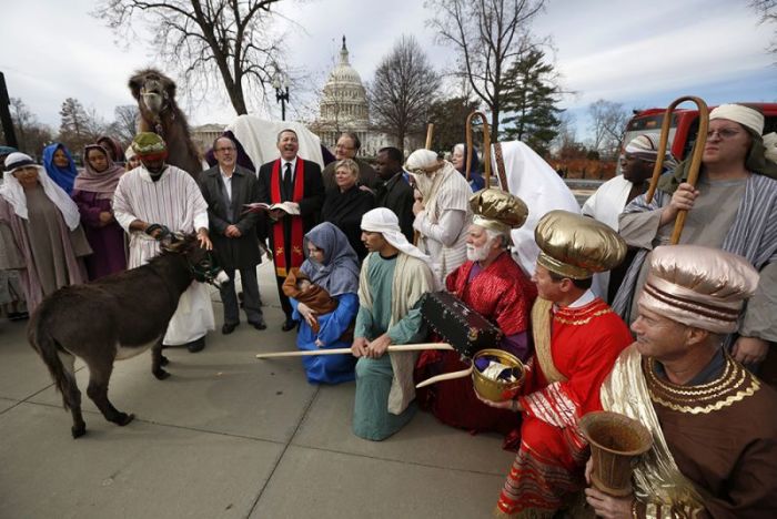 Actors dressed as Mary and Joseph carrying a baby representing Jesus, lead other actors portraying the Three Wise Men as part of a live human and animal nativity scene in front of the Supreme Court and U.S. Capitol (background) in Washington, December 5, 2012. The Christian Defense Coalition gathered to demonstrate that such displays are protected by the First Amendment. The event was a reaction to other courts involvement in the banning of nativity scenes in some parts of the United States.